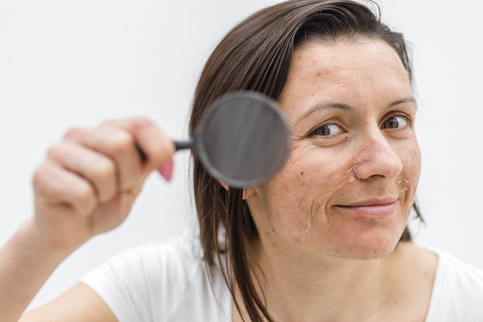 Woman holding a magnifier up to her cheek